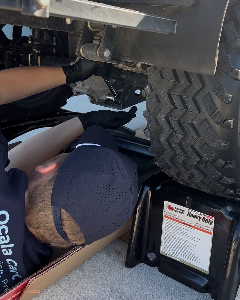 Ocala Cart Care technician performing an under-cart golf cart repair on-site